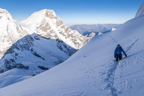 Climber wading through deep fresh snow on Chopicalqui